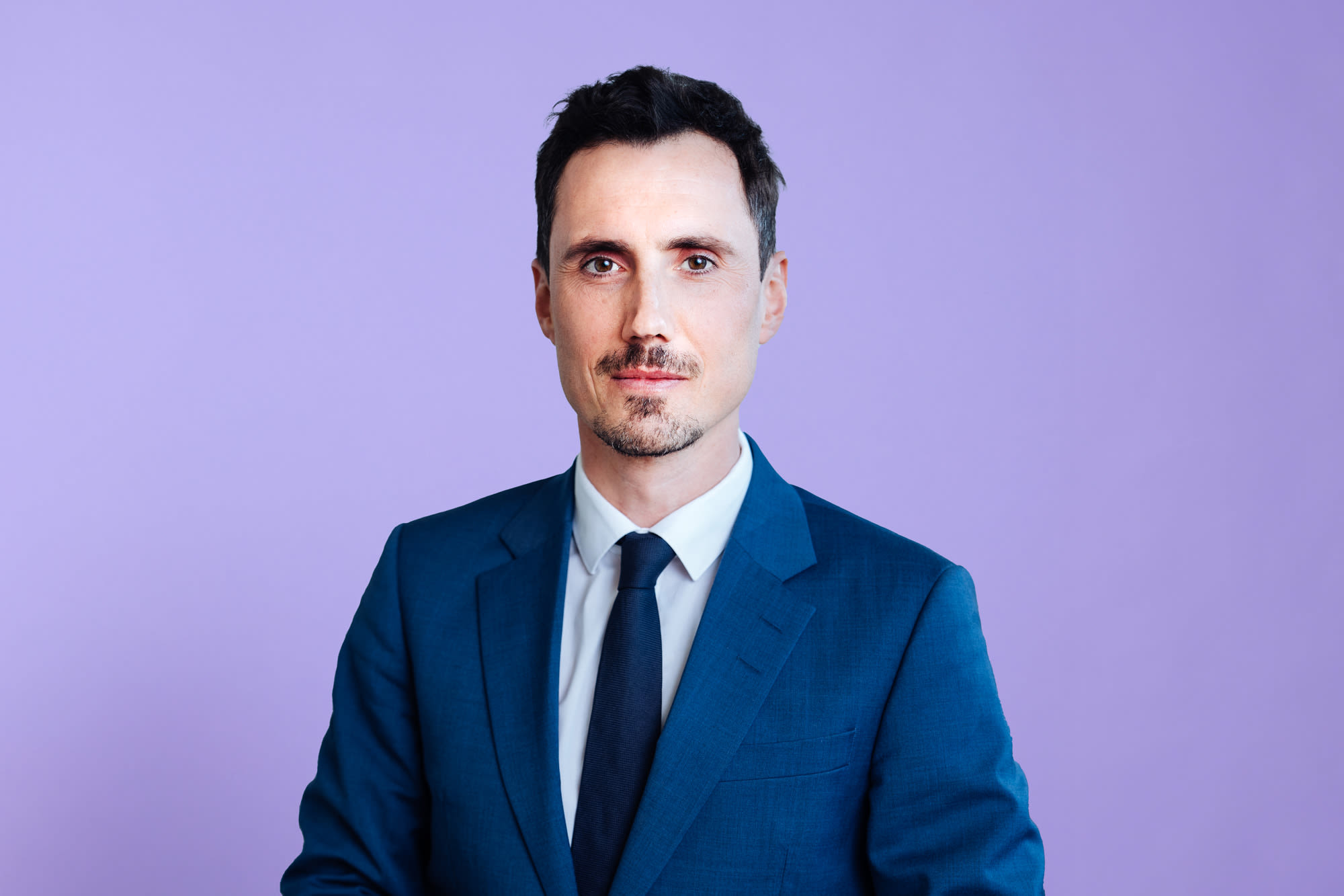 Clemens Bousquet u odelu ispred ljubičaste pozadine